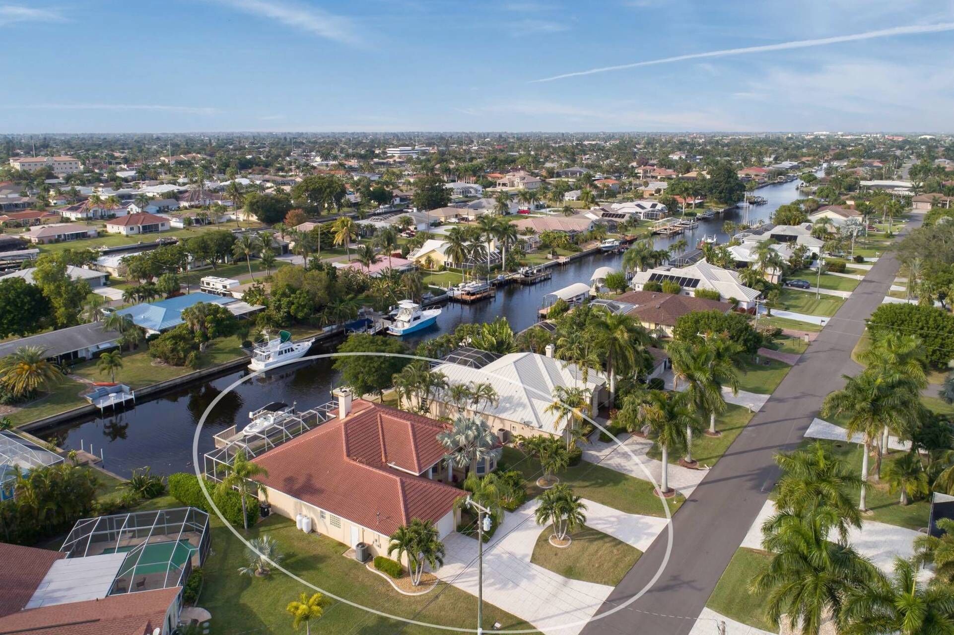 A residential area with a canal, houses, and a boat dock.