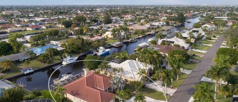 A residential area with a canal, houses, and a boat dock.
