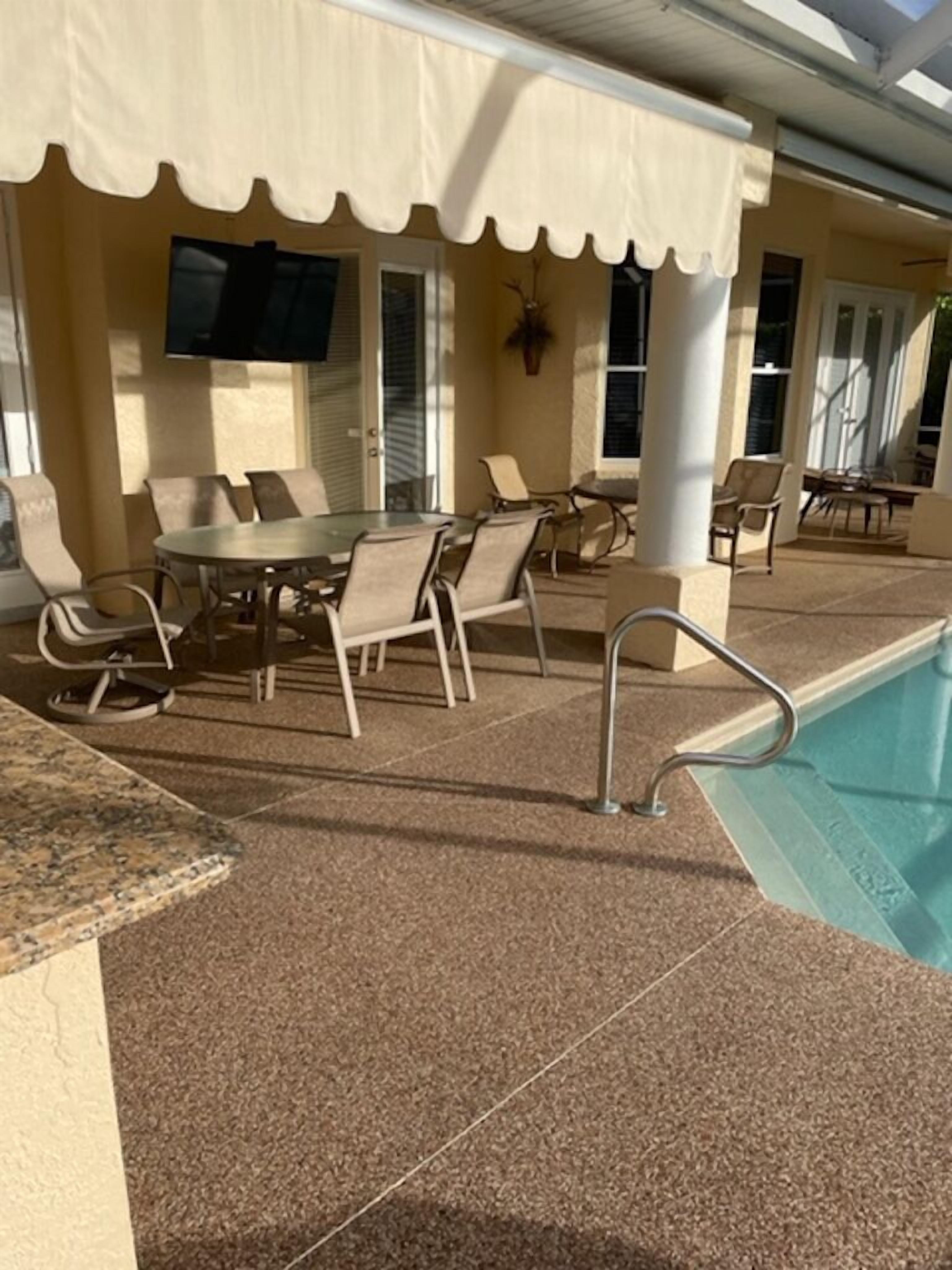 A covered outdoor seating area with a pool.