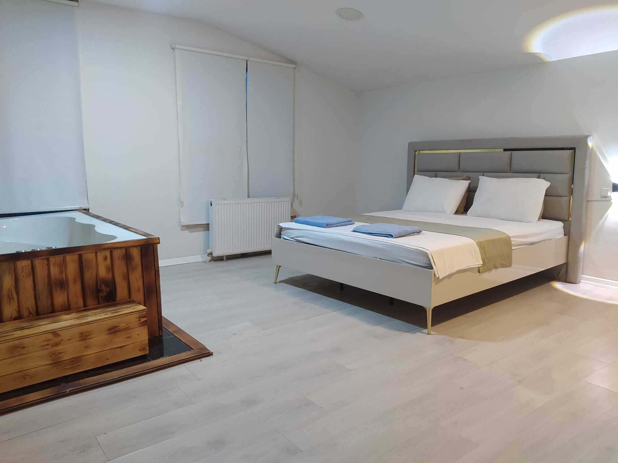 Una camera da letto con un letto, una panca in legno, un termosifone e una finestra.