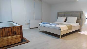 Una camera da letto con un letto, una panca in legno, un termosifone e una finestra.