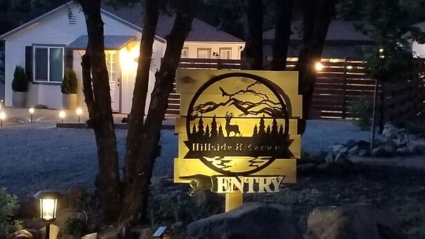 Señal de Hillridge Ranch con logotipo de un ciervo y árboles, indicando la entrada al establecimiento.