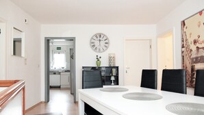 A dining area with a white table, black chairs, and a wall clock. - P1 - Large apartment at the gates of Kassel (Fuldatal)