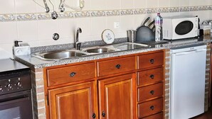 A kitchen with wooden cabinets, a stainless steel sink, a microwave, and a dishwasher. - True "Village Refuge" in Monsaraz (pets allowed!)  (Monsaraz)