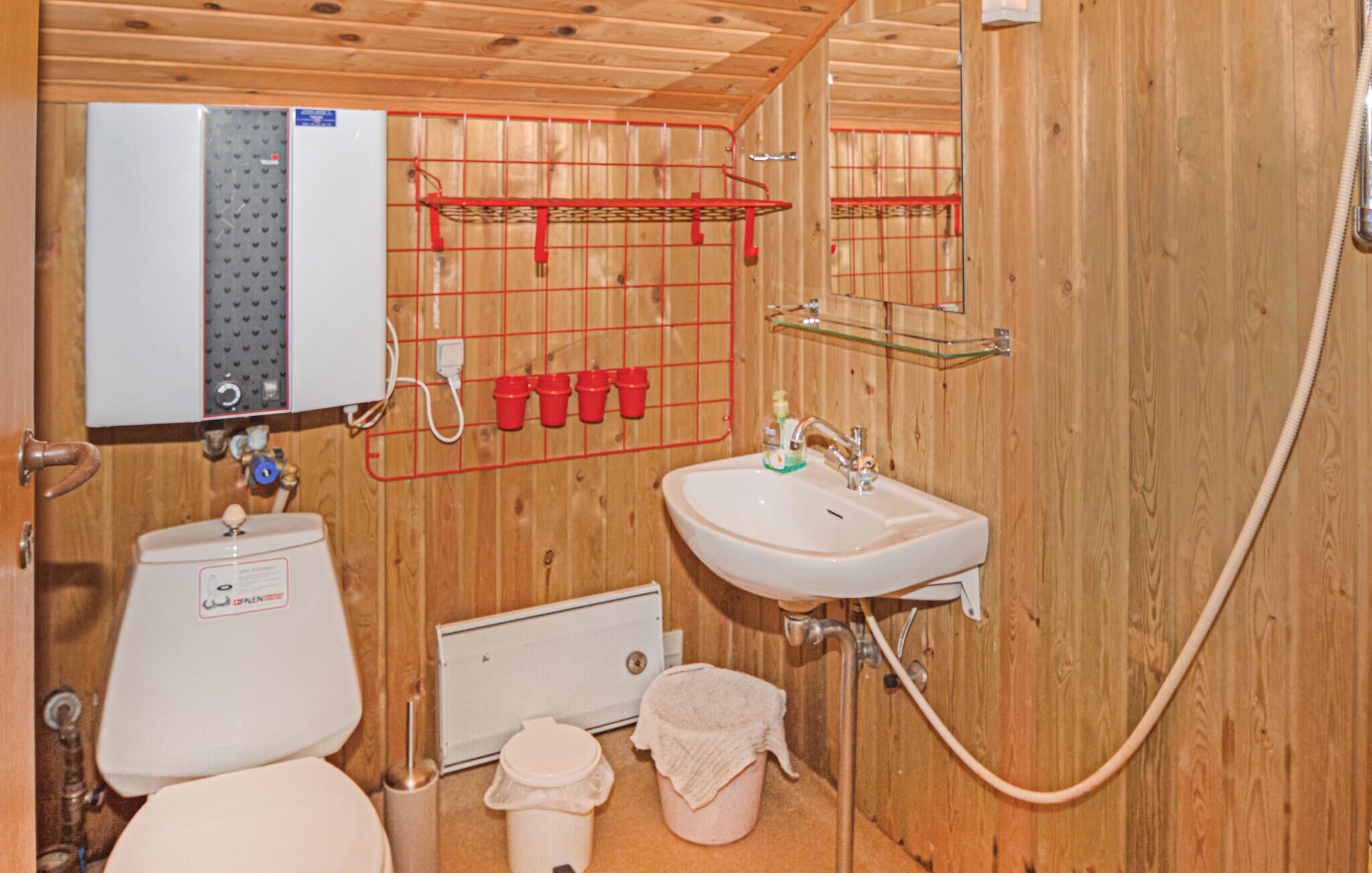 Un baño pequeño con inodoro, lavamanos y ducha.