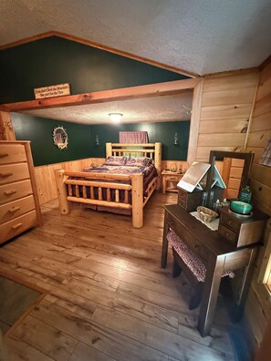 Ein Schlafzimmer aus Holz mit Bett, Kommode, Nachttisch und Spiegel.