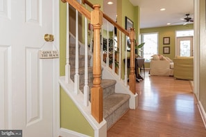 Staircase leads to a cozy living area with a sofa and small table.