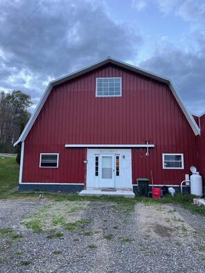 A red barn with a white door, a welcome sign, and a small window. - Cold Spring Farm Milk House Apt.- Colgate & Hamilton College (Hubbardsville)
