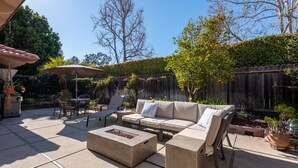 An outdoor patio with a sofa, chairs, and a table.