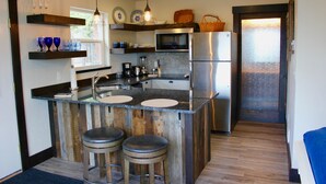 A modern kitchen with a central island, stainless steel appliances, and wooden accents. - New Montana Modern Cottage overlooking Flathead Lake (Somers)