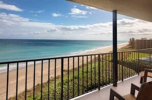 Ein Balkon mit Blick auf Strand und Meer.