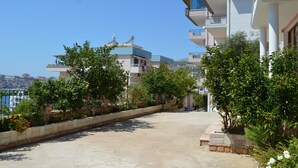 A residential area with modern buildings, a paved pathway, and greenery. - Jericho rooms (Sarandë)