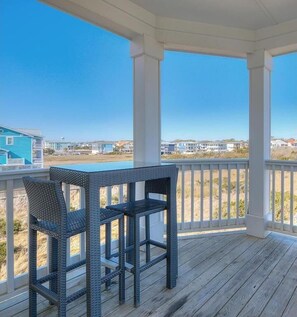 Enjoy a serene view from this elevated deck with a wicker table and chairs.