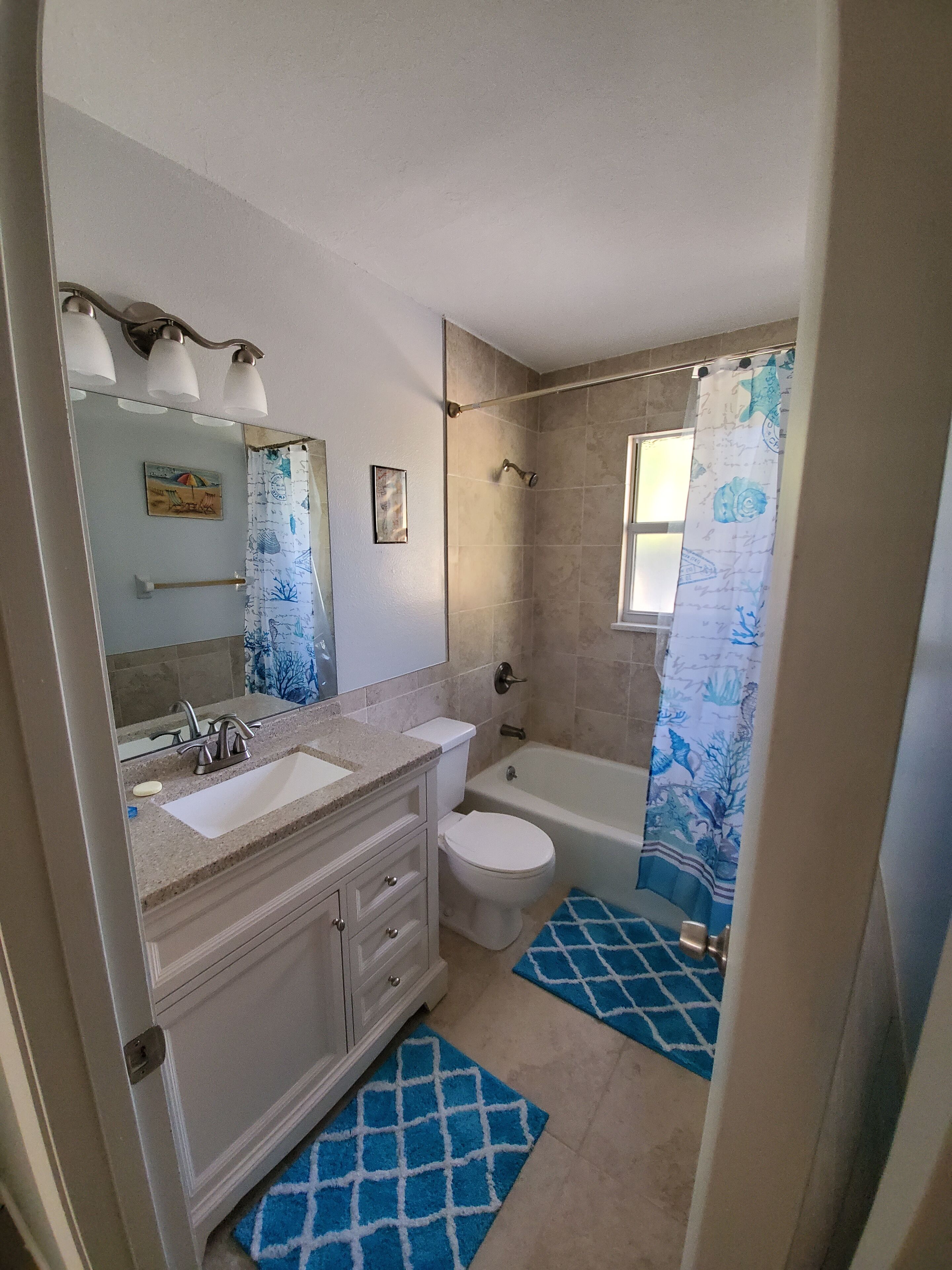 A bathroom with a double sink vanity, a toilet, a bathtub, and a shower curtain.