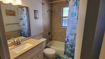 A bathroom with a sink, toilet, and bathtub.