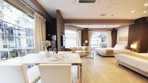 A modern hotel room with a dining area, a sofa, a bed, and large windows. - Senlax Inn Osaka (Osaka)
