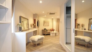 A modern living room with a herringbone floor, a sofa, a coffee table, and a television. - Senlax Inn Osaka (Osaka)