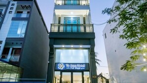 A hotel with a modern design, featuring a prominent entrance with glass doors and a signboard. - Teamo Hotel (Hai Phong)