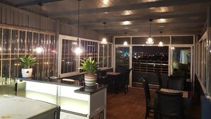 A restaurant with a terrace, outdoor seating, and hanging pendant lights. - Teamo Hotel (Hai Phong)