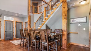 A dining area with a wooden staircase, a chandelier, and a framed picture on the wall. - THEATER/GAME ROOM w/100” Screen!! Pool Table!  Dining Seats 20! 3 Living Areas! (Hollister)