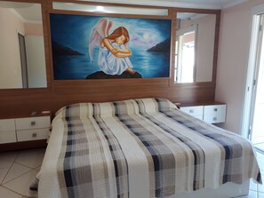 Restful retreat with a large bed, wooden headboard, and a beautiful painting above.