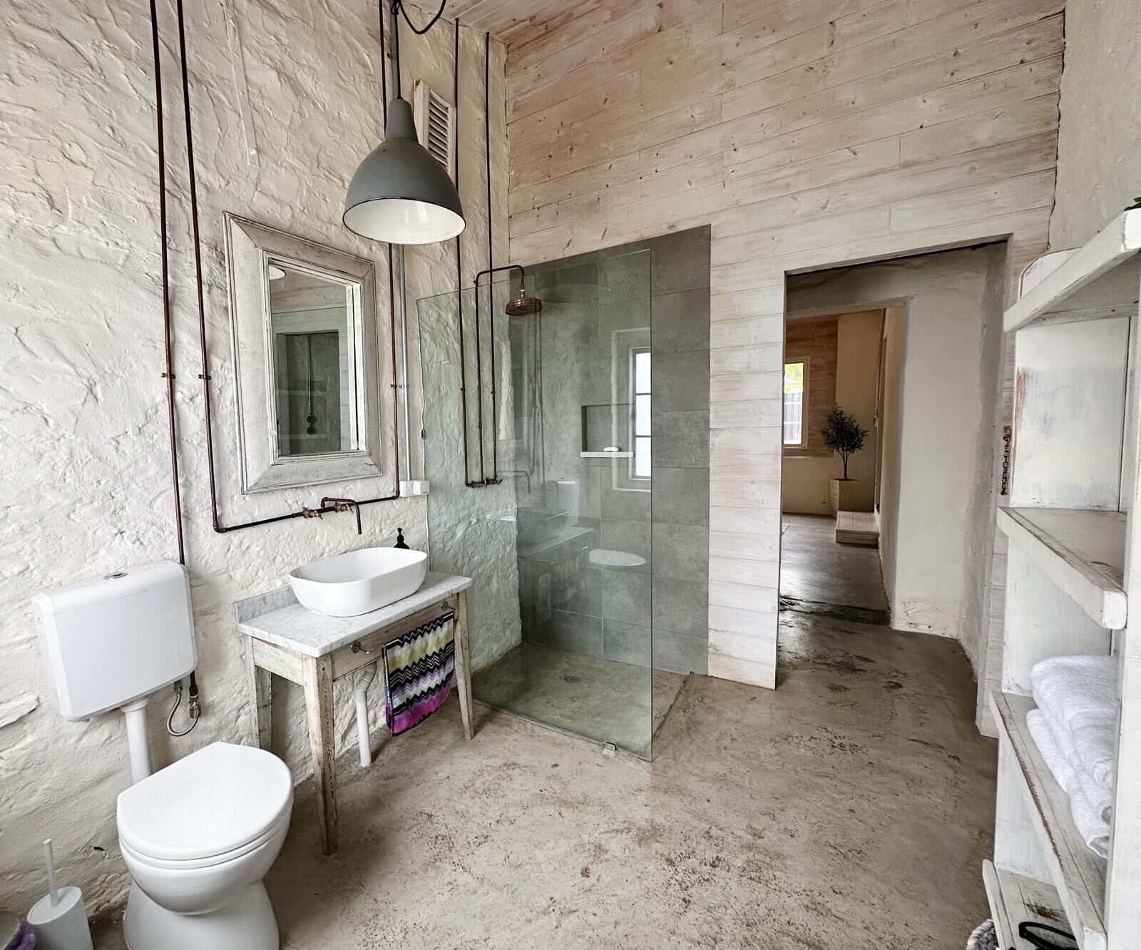 Een douche, handdoeken, zeep, toiletpapier