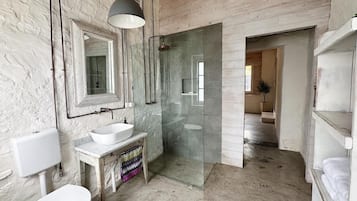 Een douche, handdoeken, zeep, toiletpapier