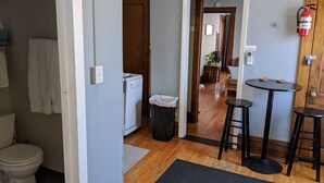 A compact kitchen with a refrigerator, a sink, and a small dining area with stools. - Great Uptown Apartment! Great Location! (Minneapolis)