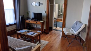 A cozy living room with a wooden desk, a television, and a comfortable chair. - Great Uptown Apartment! Great Location! (Minneapolis)