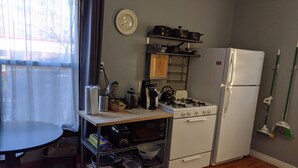 A compact kitchen with a stove, refrigerator, and a small dining table. - Great Uptown Apartment! Great Location! (Minneapolis)
