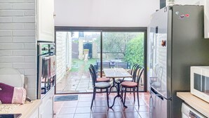 A kitchen with a refrigerator, a microwave, and a dishwasher. There is a dining area with a table and chairs. - Stunning home in Orange (Orange)