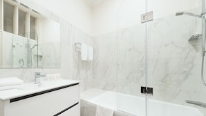 A modern bathroom with a glass-enclosed shower, a white vanity with a mirror, and a bathtub. - Stunning Sydney Home 8 (Millers Point)