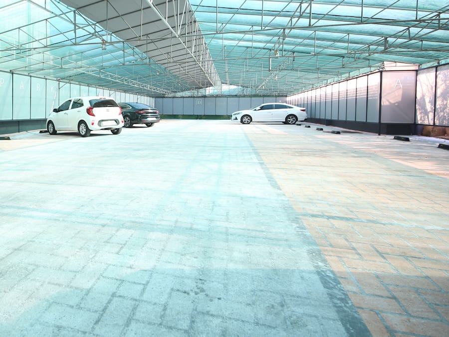 A covered parking area with multiple cars parked.