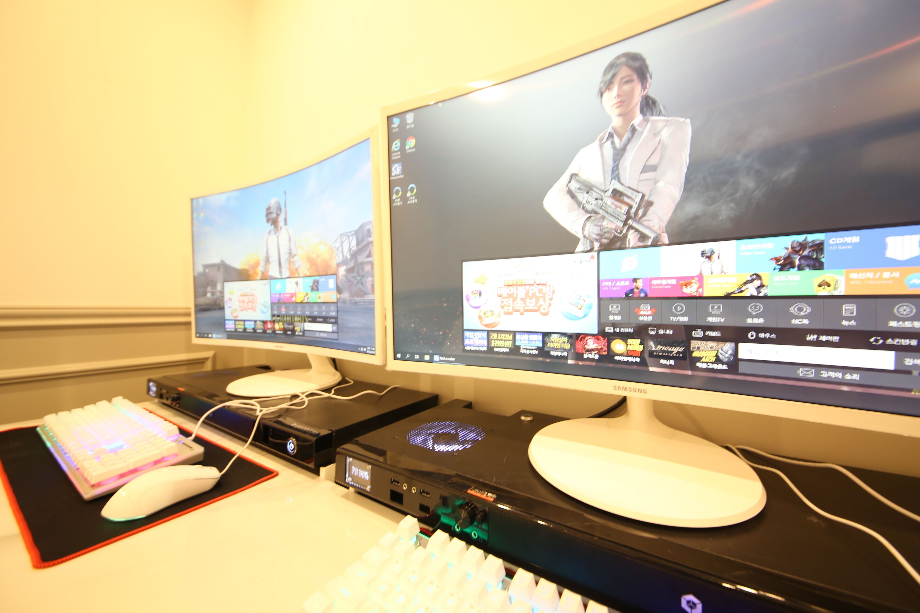 Ein Dual-Monitor-Setup mit Gaming-Maus und -Tastatur, einer Soundkarte und einem Gaming-PC.