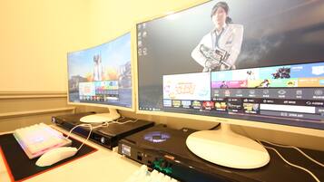 Ein Dual-Monitor-Setup mit Gaming-Maus und -Tastatur, einer Soundkarte und einem Gaming-PC.