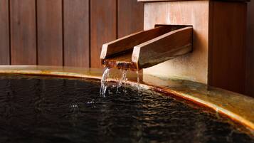 A wooden water feature with a rectangular basin and a wooden structure above it.