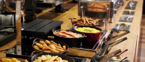 A buffet with various food items including fried chicken, French fries, and other dishes.