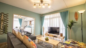 Un salon moderne avec un canapé, un téléviseur et une table basse.