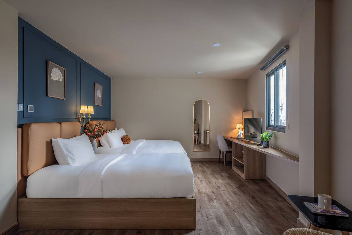 Une chambre d’hôtel moderne avec un grand lit, un bureau, une chaise et une fenêtre.