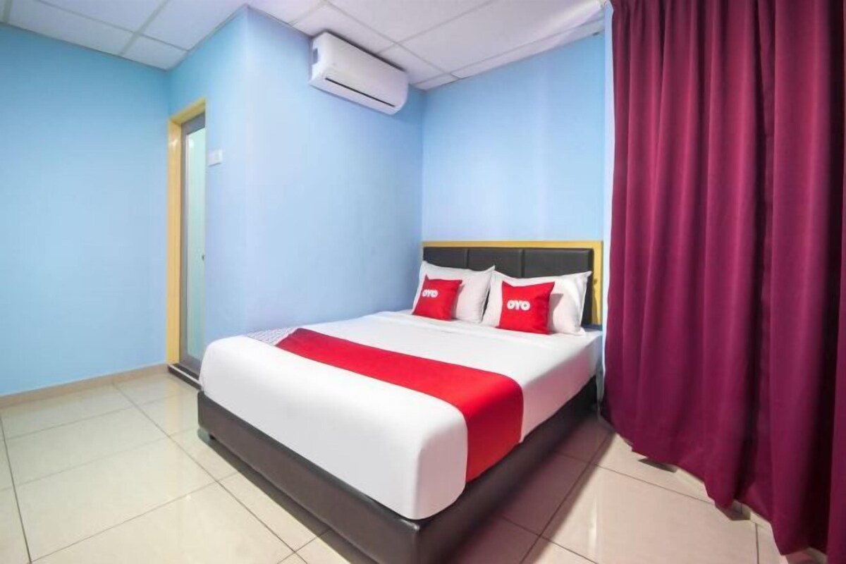 Ein Hotelzimmer mit einem Bett, einer Tür und einem Vorhang.