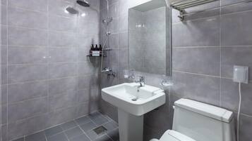 A modern bathroom with grey tiles, a white sink, a toilet, and a shower area.