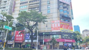 A multi-story building with various commercial establishments, including a hotel, a fitness center, and a furniture store. - Newhotel (Kaohsiung)
