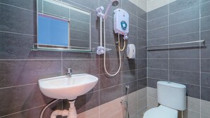 A bathroom with a white sink, a toilet, a handheld showerhead, and a wall-mounted water heater. - Hotel O My Budget Home (George Town)