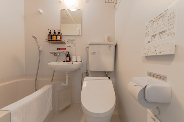 A modern bathroom with a bathtub, toilet, sink, and shower.