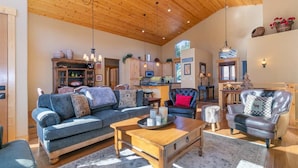 A cozy living room with a wooden ceiling, a sofa, a coffee table, and a leather armchair. - 5bd3ba, sleeps 10 Mountain View Hot Tub/Poker/Pool table, near Ski Resort (Truckee)