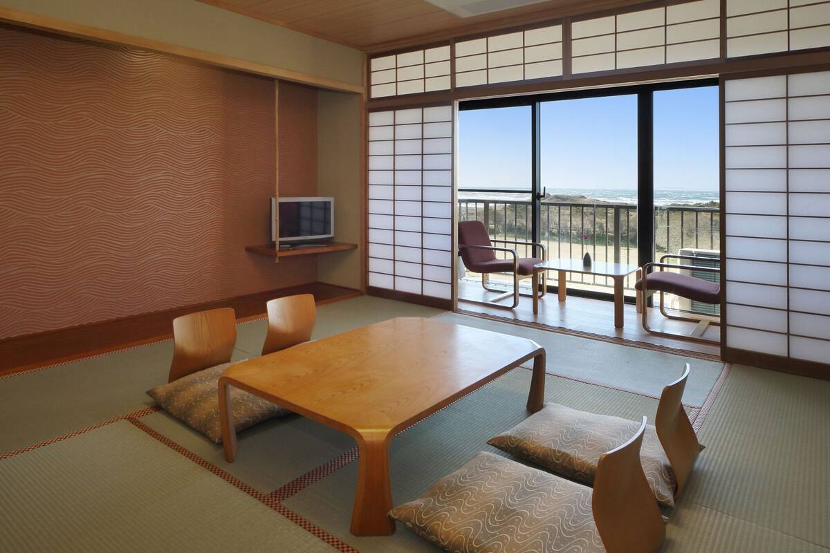 A traditional Japanese room with tatami flooring, a low table, and sliding shoji doors.