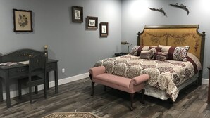 A bedroom with a bed, a desk, a chair, and a bench.