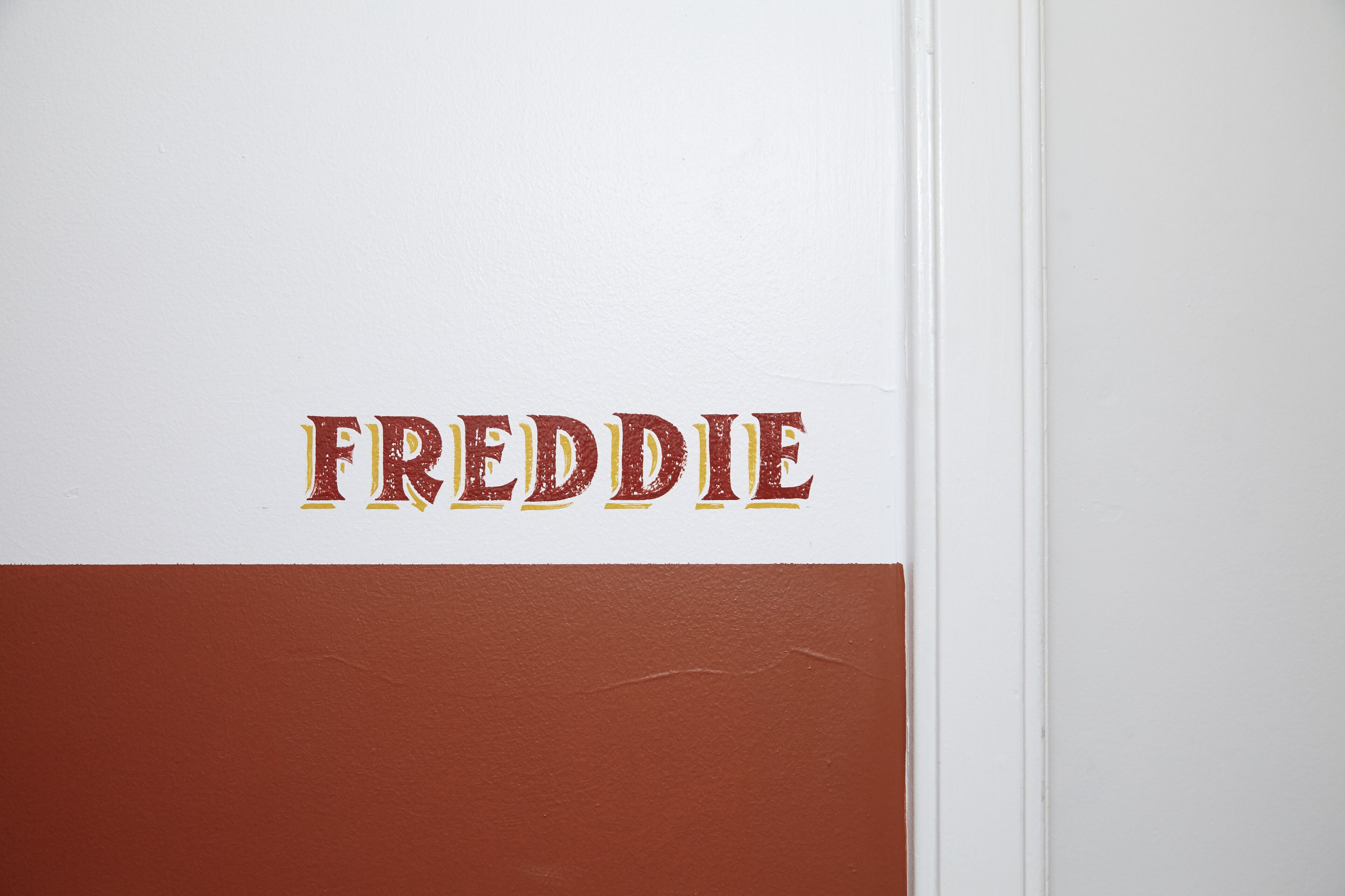 A wall with the name "FREDDIE" in bold letters.