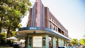 Un bâtiment sur lequel on peut lire l’inscription « ERKO » et « BISTRO OUVERT TOUTE LA JOURNÉE, CHATS ET RONRON ».