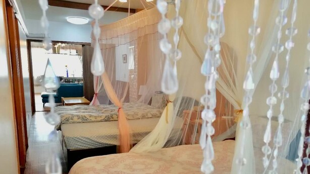 A bedroom with two beds, each with a canopy. - YokohamaKannai HouseBar (Yokohama)